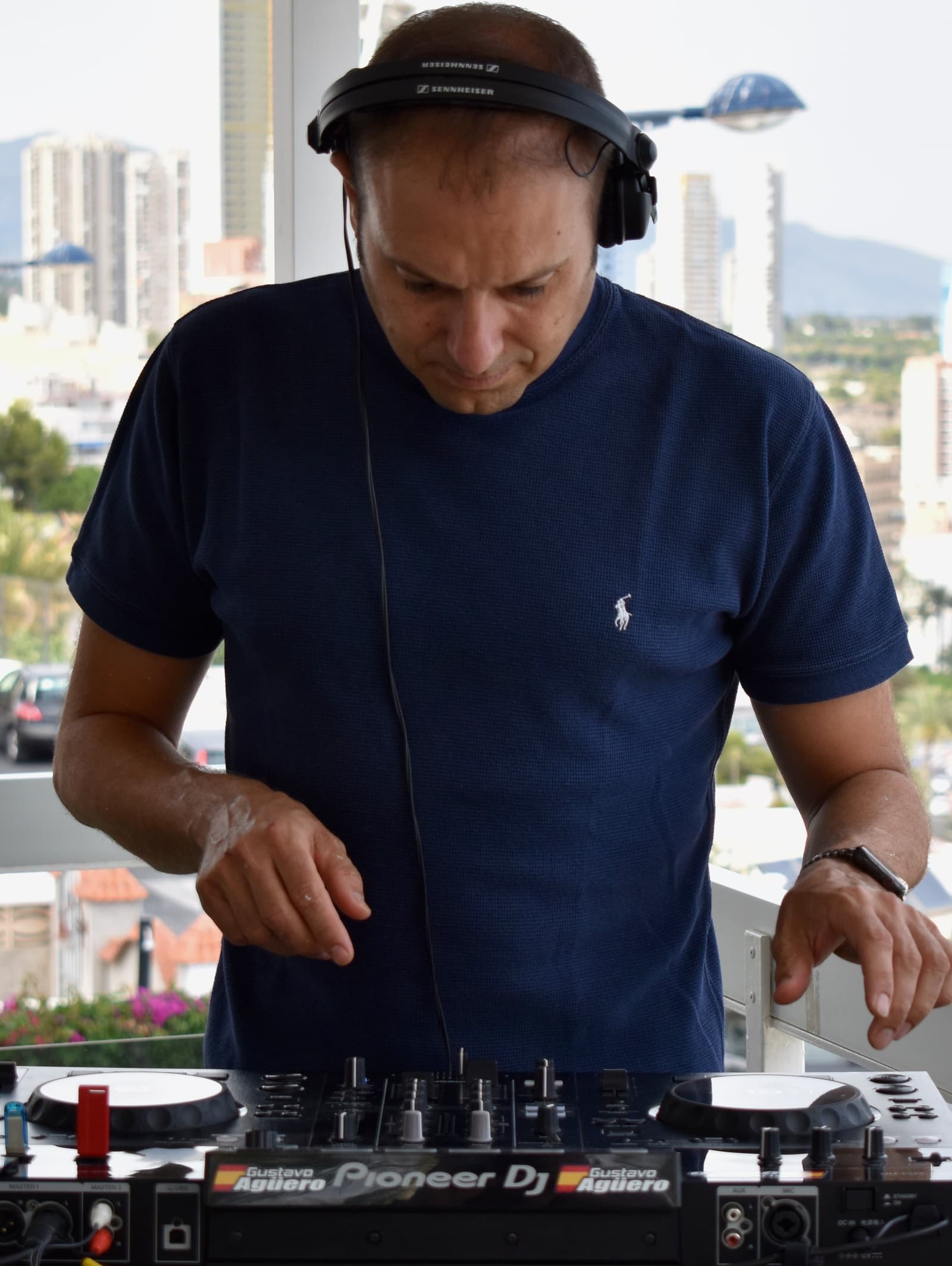 Gus Aguero DJ pinchando con el skyline de Benidorm de fondo
